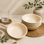Round natural-tone bowls with smooth curved sides and a visible leaf-grain finish.