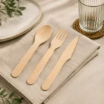 A natural-tone cutlery selection comprising a spoon, fork and serrated-edge knife.