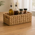 A rectangular woven caddy with raised sides for organising bottles and condiments on a dining table.