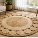 A round jute rug with a pale inner band and a decorative border of repeated circular motifs.