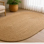 An oval jute rug with continuous concentric braiding and a simple natural-tone finish.
